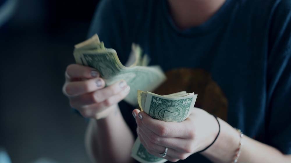 Dollar Bills in Hands Illustrates Cash Flow for Small Business