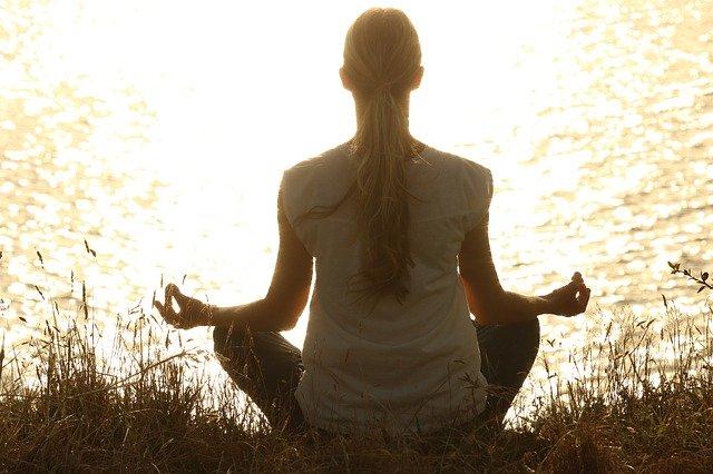 Woman Meditating On Lake