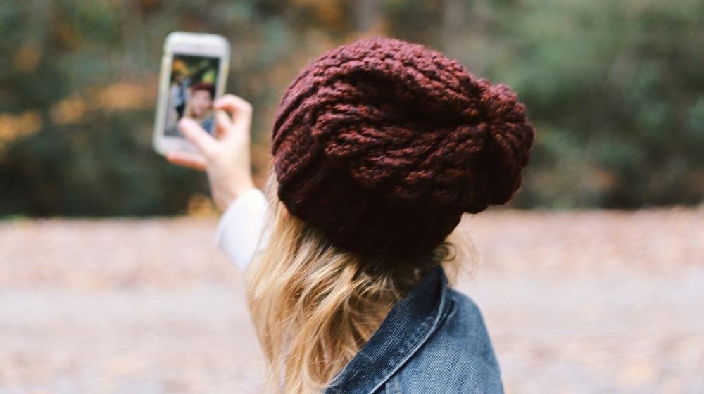 Woman Recording Self On Phone Illustrating Facebook Live