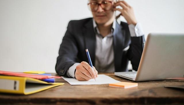 Businessman Talking On The Phone And Taking Notes