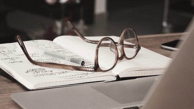 How To Become A Mentor Glasses Resting on Open Notebook Near Laptop