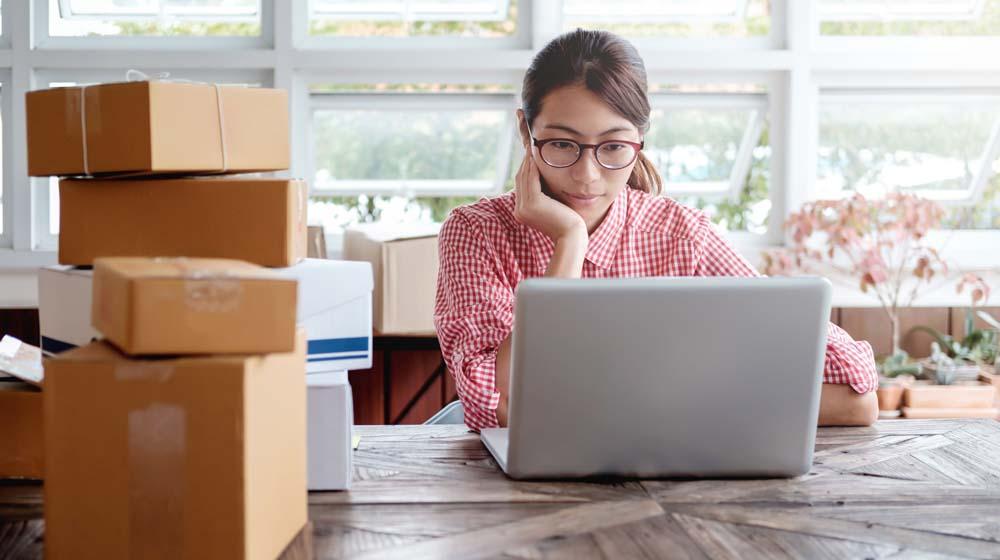 How to File Taxes Online Seller Looking at Laptop with Boxes