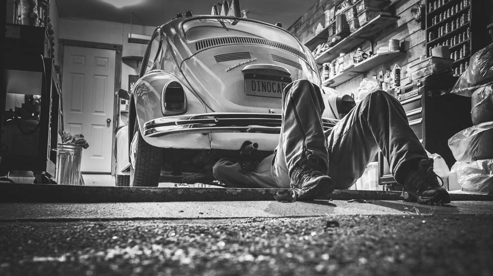 Repair man working under car