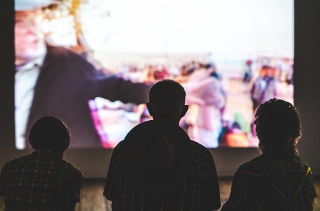 Three Men Watching Projected Video