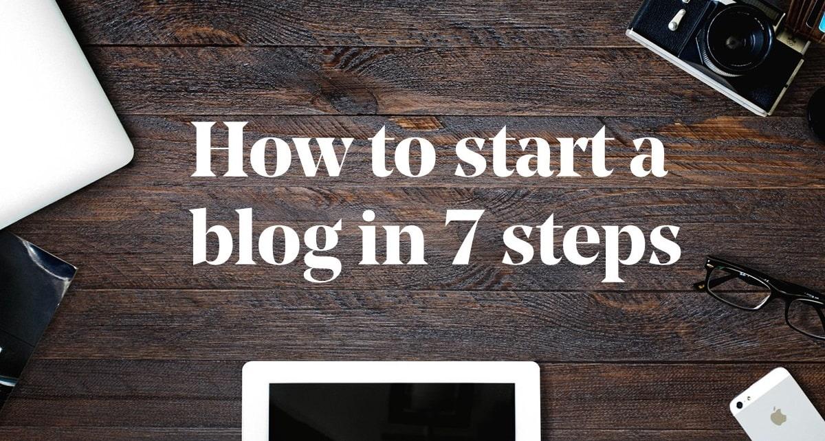 How To Start A Blog In 7 Steps Banner With Laptop, Tablet, Glasses And Camera