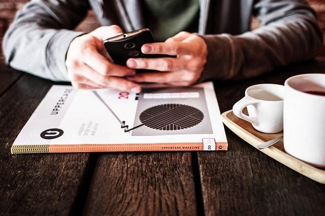 Man At Desk On Smartphone Illustrates Email Contact List