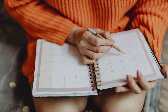 Woman Writing On Calendar Page