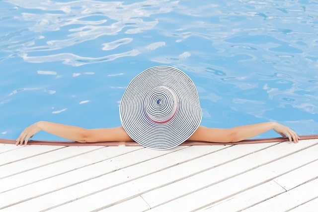 Woman Wearing A Large Hat Relaxing In A Pool