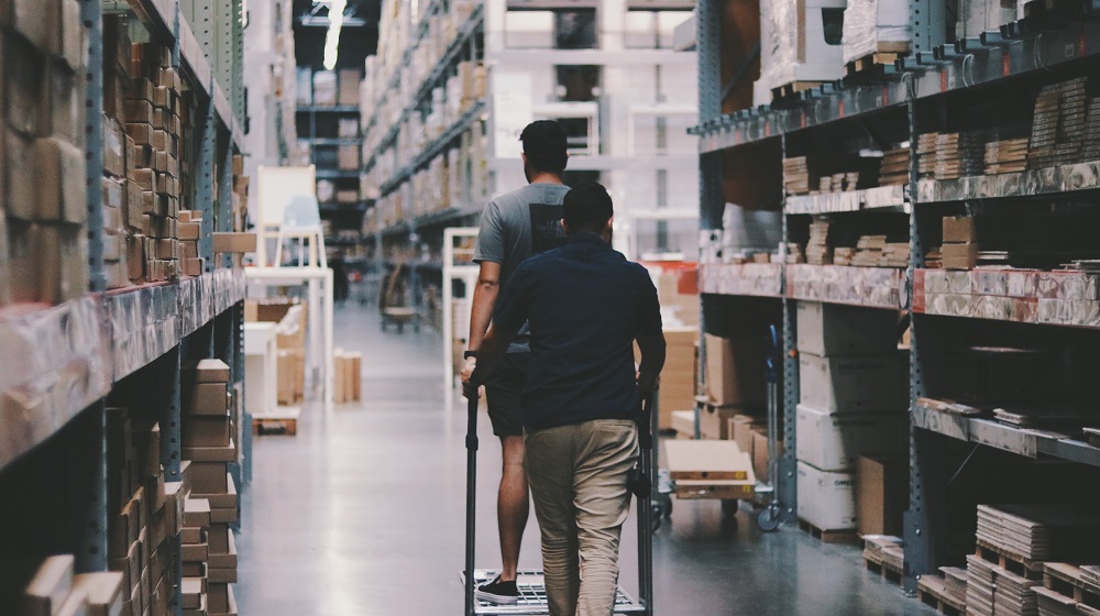 Two Men Walking Through Warehouse Illustrating Selling Excess Inventory