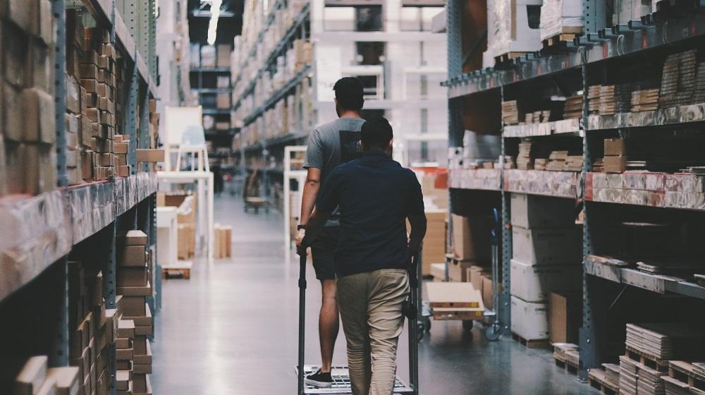 Two Men Walking Through Warehouse Illustrating Selling Excess Inventory