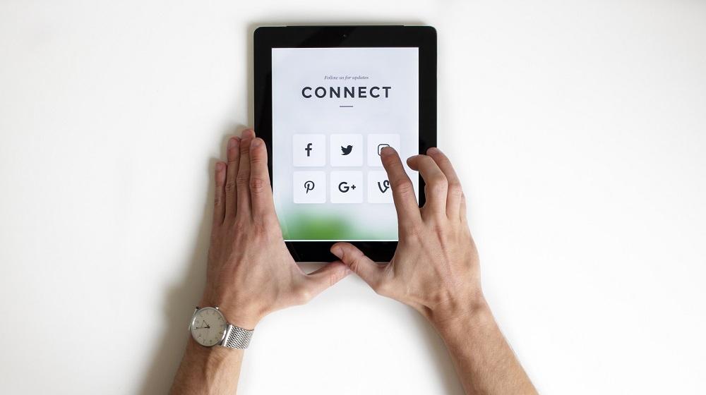 Hands Holding A Tablet Showing Connect Above Different Social Media Choices