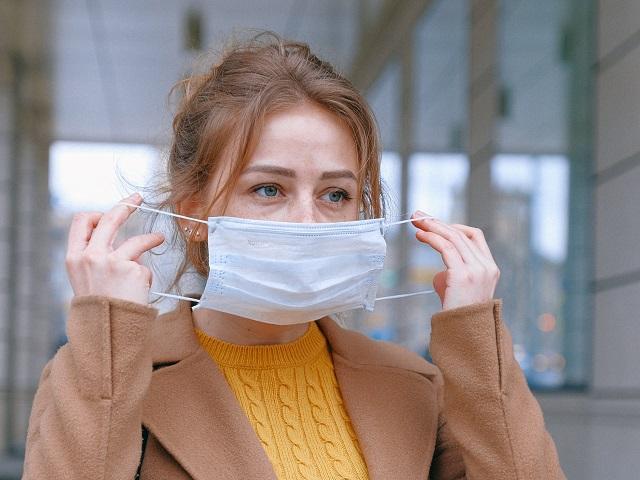 Woman Putting On Face Mask