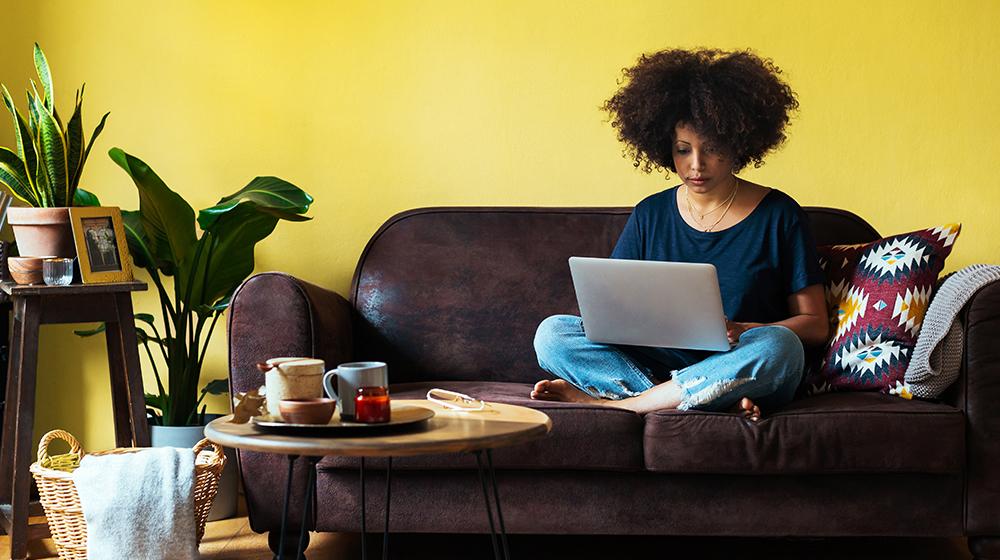 woman sitting on couch with laptop
