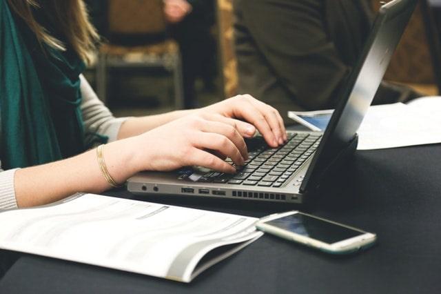 A Pair of Hands Types on a Laptop Keyboard