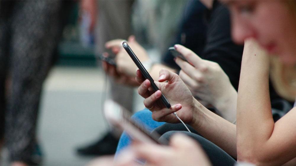 Woman Looking at Mobile Phone Illustrates Making Easy for Customers to Contact Business