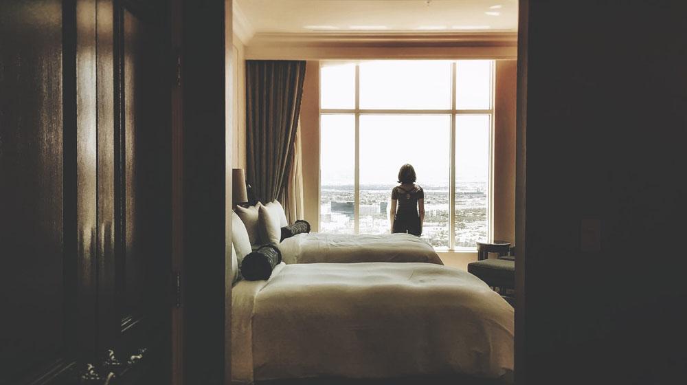 Woman Standing at Hotel Window Illustrates Lodging Website Updates